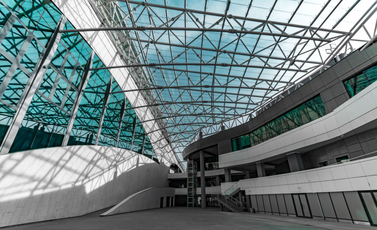 Modern architectural space with high glass ceilings and steel structures.